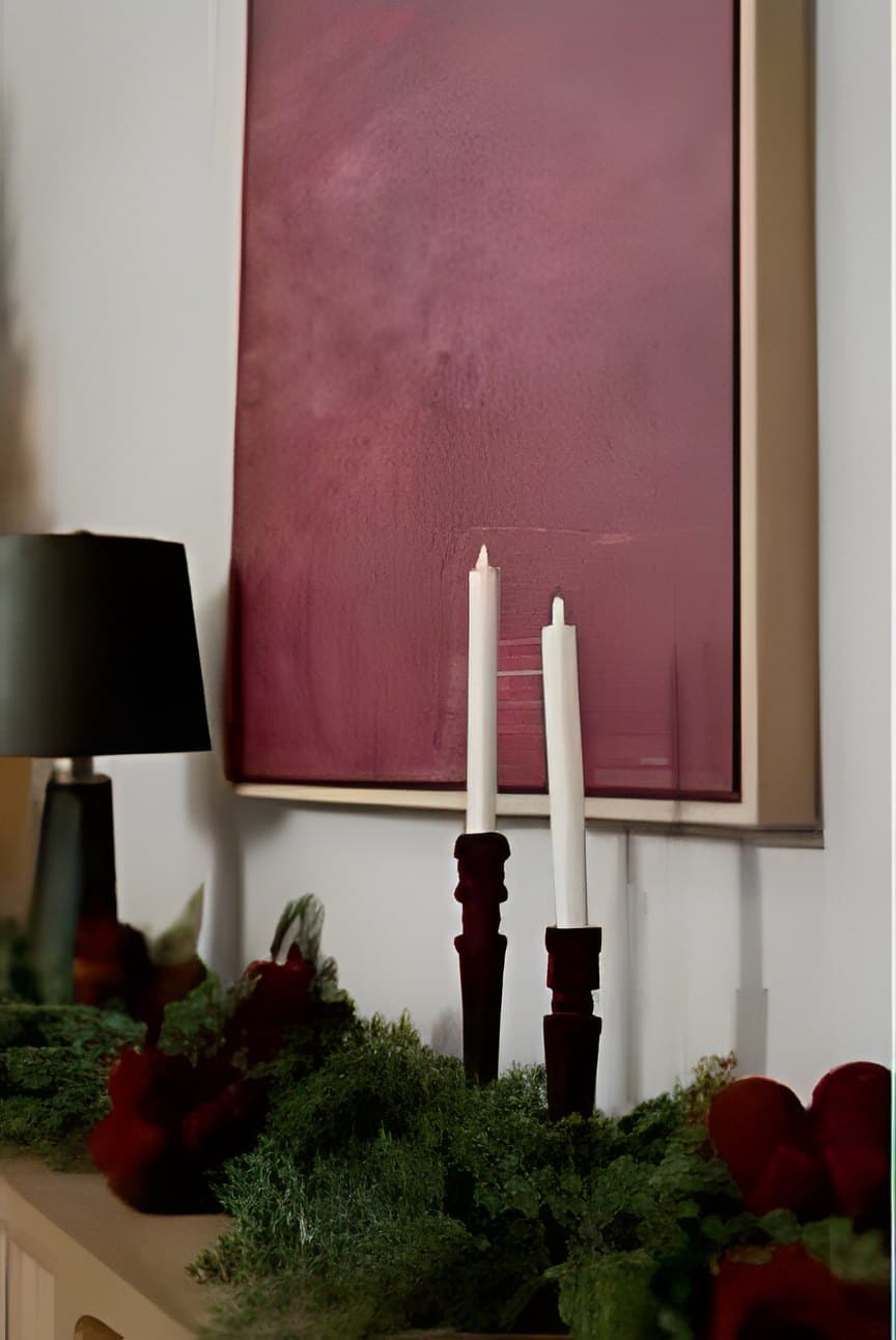 Taper candles and a pine garland with red roses on the sideboard of the Yonkers Christmas studio set