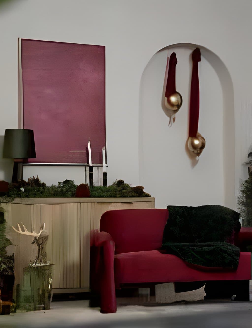 The burgundy velvet loveseat with a green throw under an arched alcove hung with gold ornaments, in the Yonkers Christmas studio