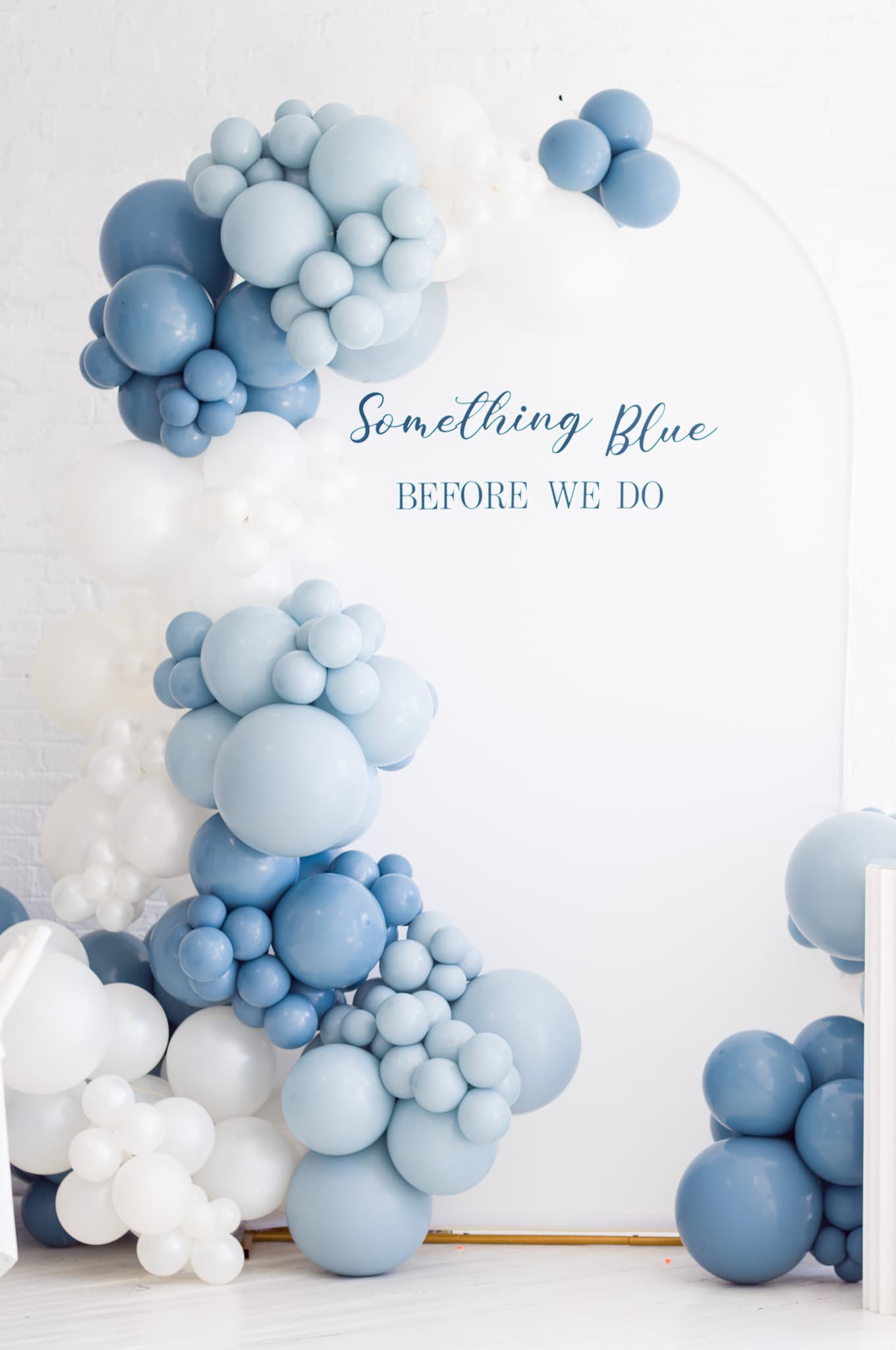 The "Something Blue Before We Do" balloon arch in dusty blue and white