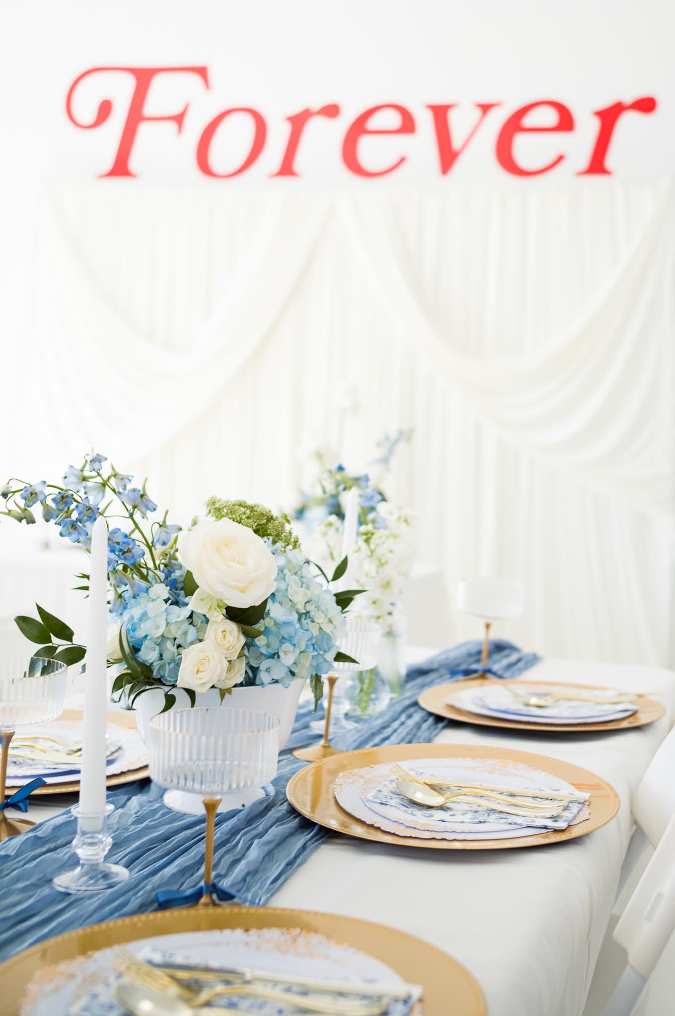 The "Forever" tablescape with draped backdrop, florals, and place settings