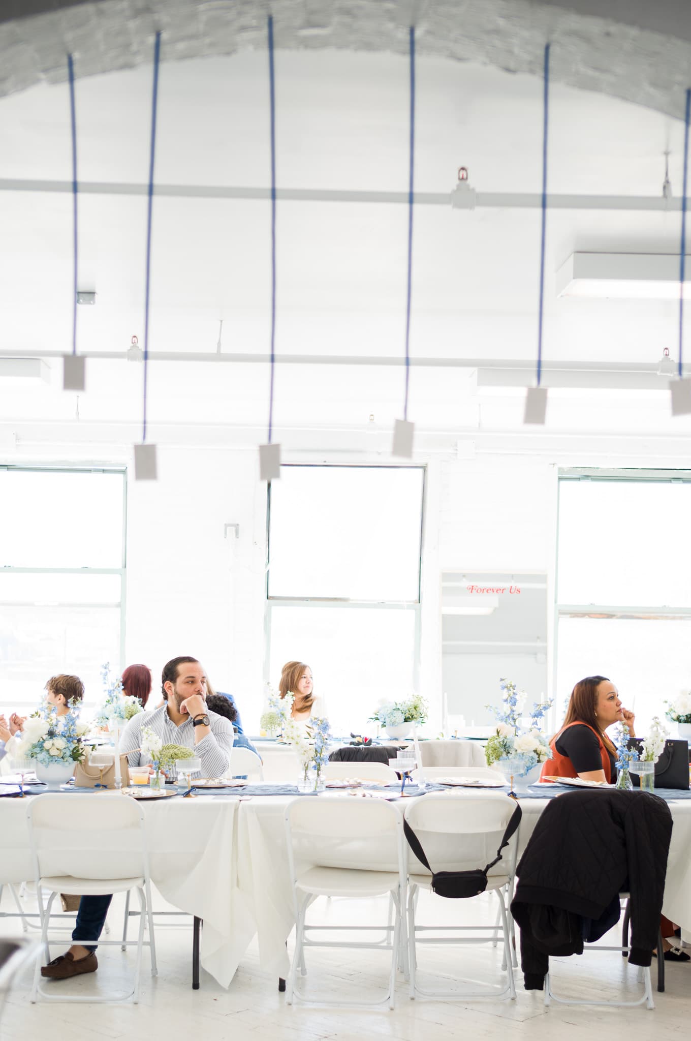 Guests seated at the long table inside the loft venue