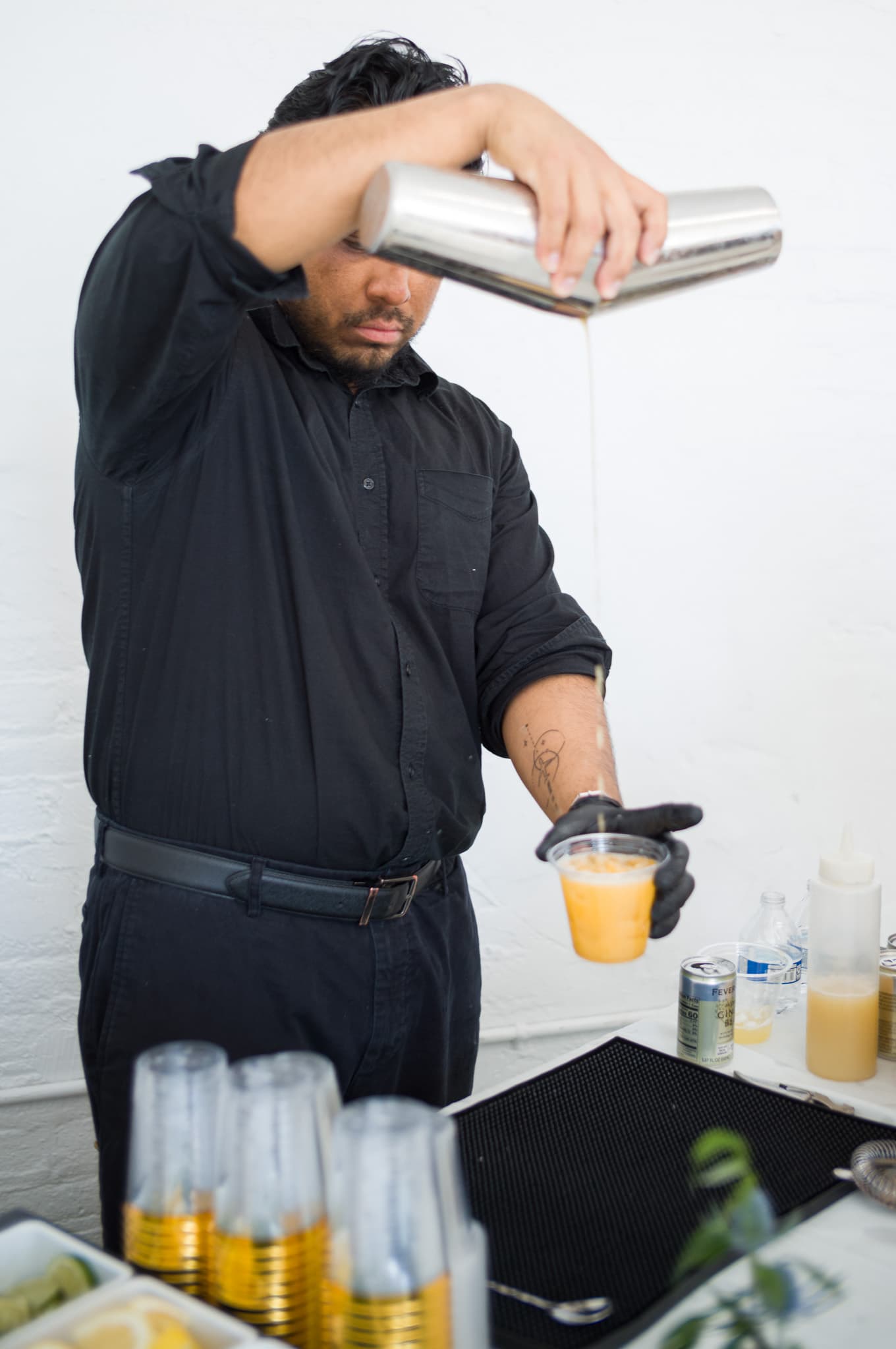 The bartender pouring a fresh cocktail from a shaker