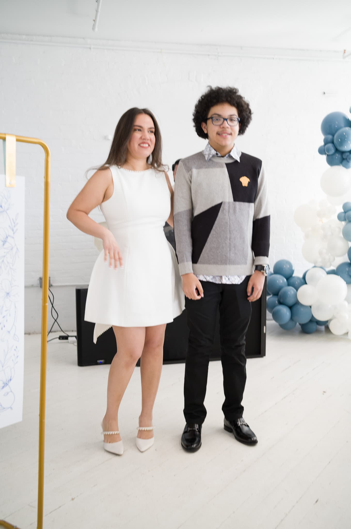 Jinet and a guest posing together in front of the balloon arch