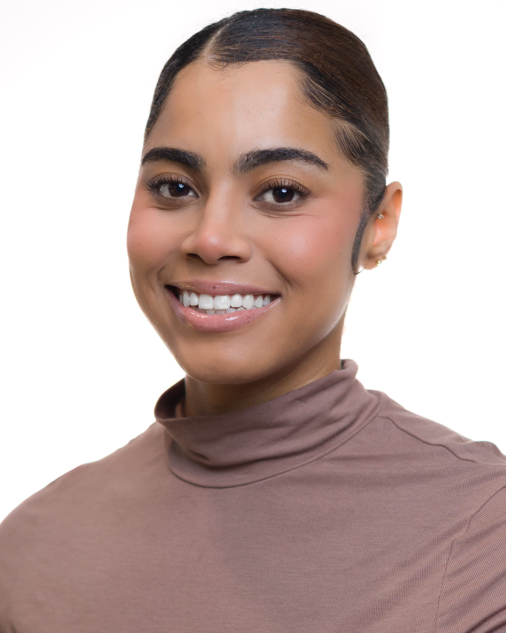 Smiling woman with dark hair in a brown turtleneck, professional headshot by Fuentes Studio